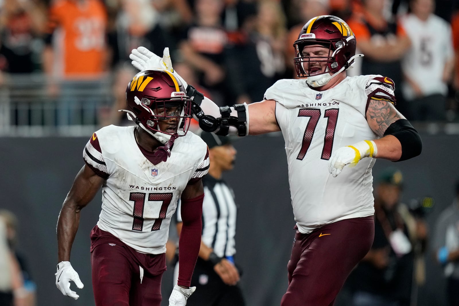 Washington Commanders wide receiver Terry McLaurin (17) celebrates with teammate Andrew Wylie (71) after catching a 27-yard touchdown pass during the second half of an NFL football game against the Cincinnati Bengals, Monday, Sept. 23, 2024, in Cincinnati. (AP Photo/Carolyn Kaster)