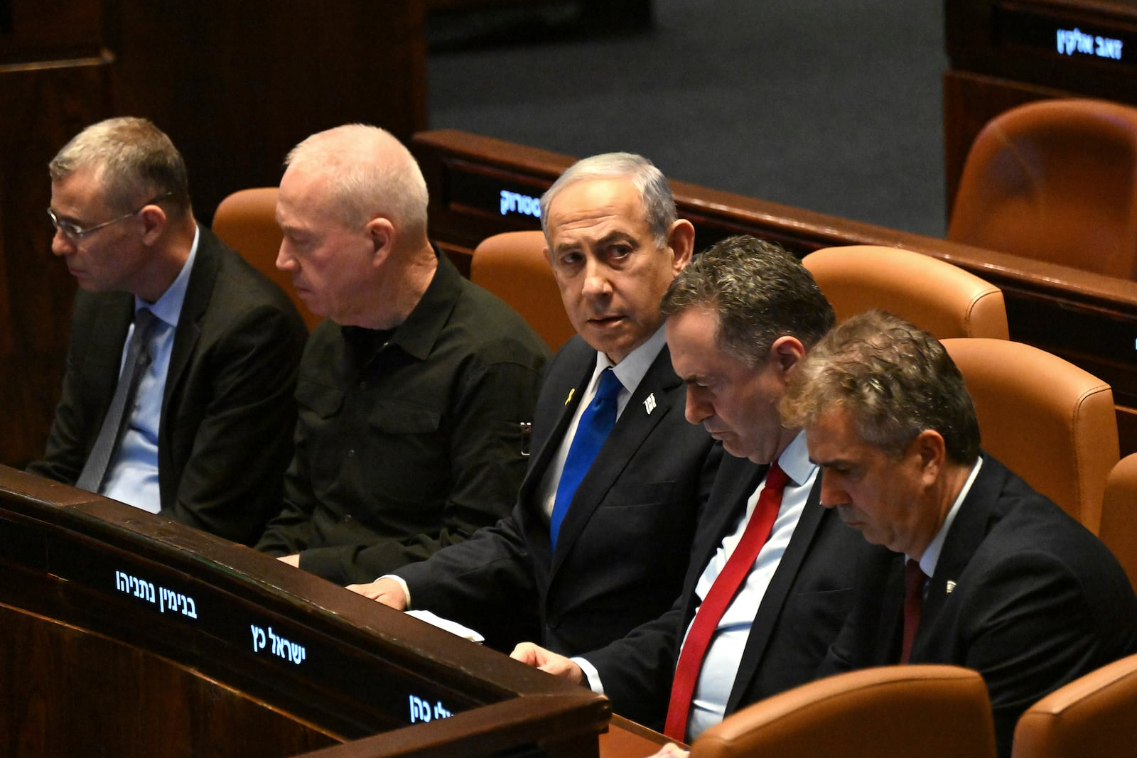 Israeli Prime Minister Benjamin Netanyahu, center, flanked by Defense Minister Yoav Gallant, second from left, attends at the opening of the 25th Knesset session marking the anniversary of the "Iron Swords" war, in Jerusalem, Monday, Oct. 28, 2024. (Debbie Hill/Pool Photo via AP)