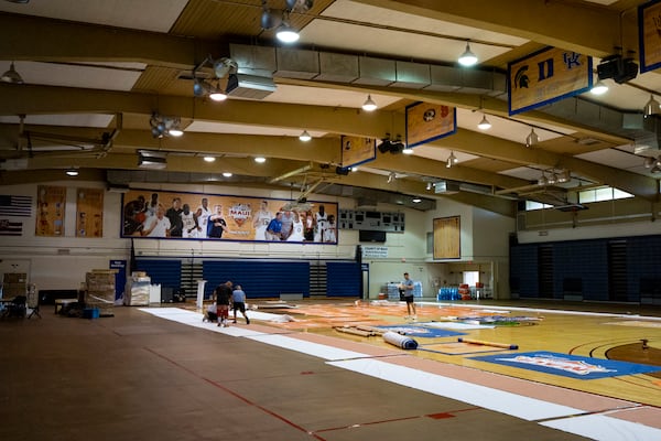 Workers set up banners and signs at Lahaina Civic Center, the venue for the Maui Invitational, Monday, Nov. 18, 2024, in Lahaina, Hawaii. The Maui Invitational is back in Lahaina, where eight of the NCAA's top men's basketball teams will compete in a three-day tournament. (AP Photo/Mengshin Lin)