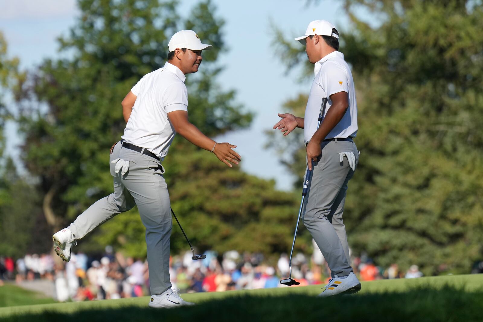 International team member Si Woo Kim, right, of South Korea, celebrates with partner Tom Kim, left, also of South Korea, after a birdie putt on the fifth hole during a fourth-round foursomes match at the Presidents Cup golf tournament at Royal Montreal Golf Club in Montreal, Saturday, Sept. 28, 2024. (NathanDenette/The Canadian Press via AP)