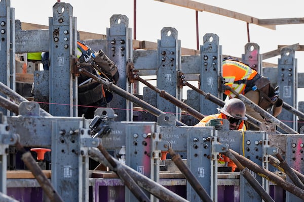 Carpenters with the California High-Speed Rail Authority work on a parapet and derailment wall at the Hanford Viaduct construction site, Tuesday, April 15, 2025, in Kings County, Calif. (AP Photo/Godofredo A. Vásquez)