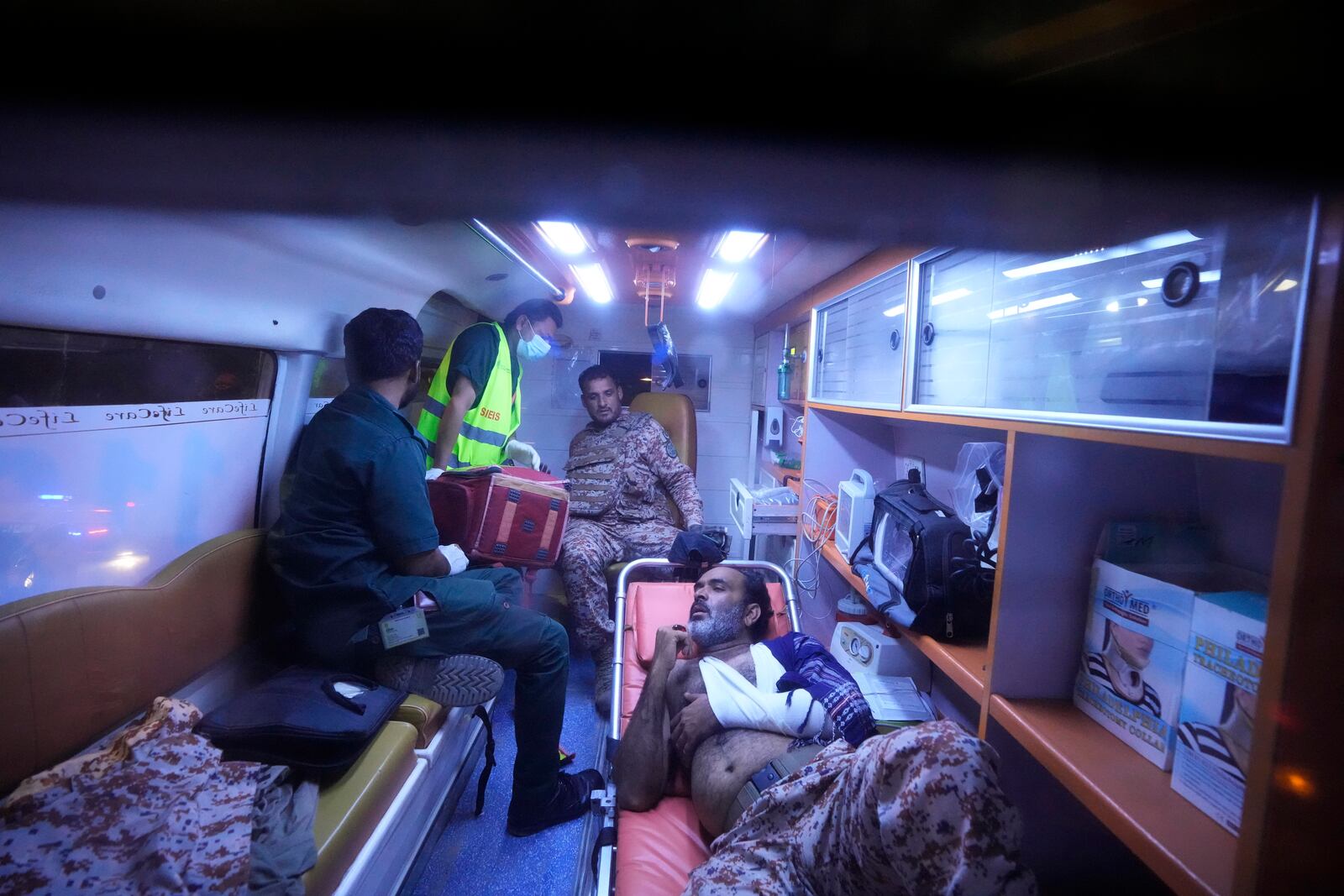 Pakistani security officials who were injured in an explosion receives treatment inside an ambulance outside the Karachi airport, Pakistan, Monday, Oct. 7, 2024. (AP Photo/Fareed Khan)