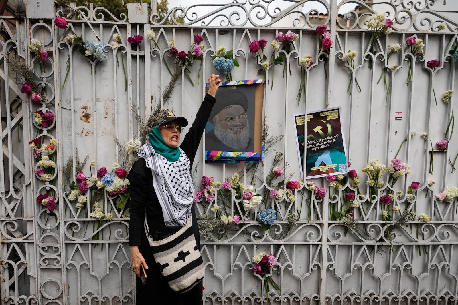 A woman shouts slogans with a painting of late Hezbollah leader Hassan Nasrallah in front of the Lebanese Embassy during a pro-Palestinian rally in Bogota, Colombia, Monday, Oct. 7, 2024. (AP Photo/Fernando Vergara)