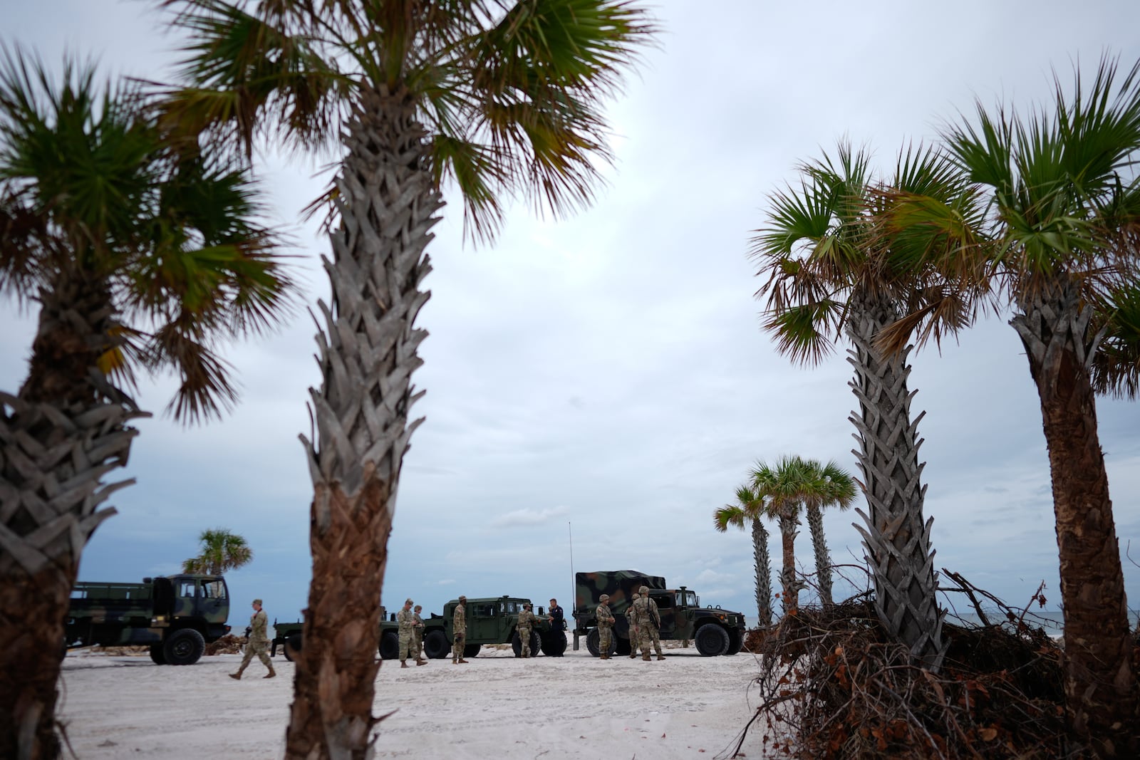 Members of the Florida Army National Guard stage on a beach as they prepare for the arrival of Hurricane Milton, in Bradenton Beach on Anna Maria Island, Fla., Tuesday, Oct. 8, 2024. (AP Photo/Rebecca Blackwell)