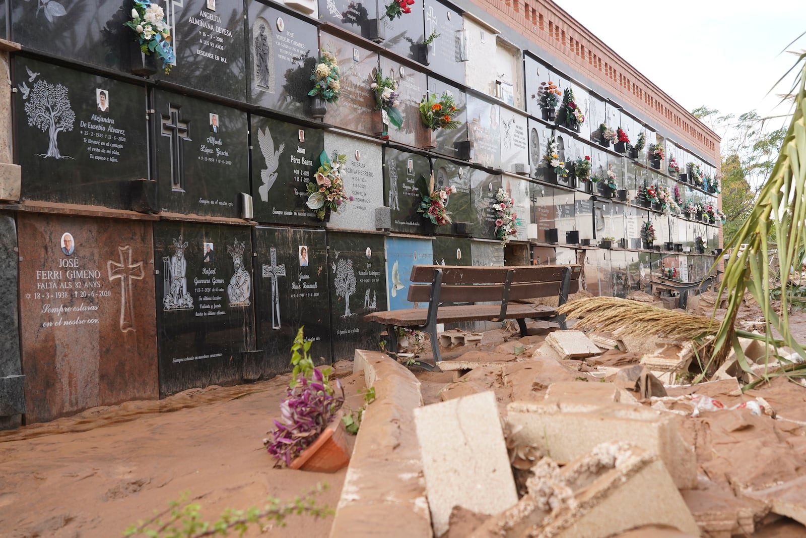 Broken tombstones and debris is seen inside a flood damaged cemetery on the outskirts of Valencia, Spain, Friday, Nov. 1, 2024 after flooding in the region. (AP Photo/Alberto Saiz)