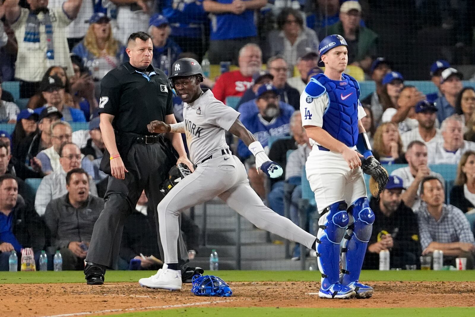 New York Yankees' Jazz Chisholm Jr. scores past Los Angeles Dodgers catcher Will Smith after a ground ball by Anthony Volpe during the 10th inning in Game 1 of the baseball World Series, Friday, Oct. 25, 2024, in Los Angeles. (AP Photo/Mark J. Terrill)