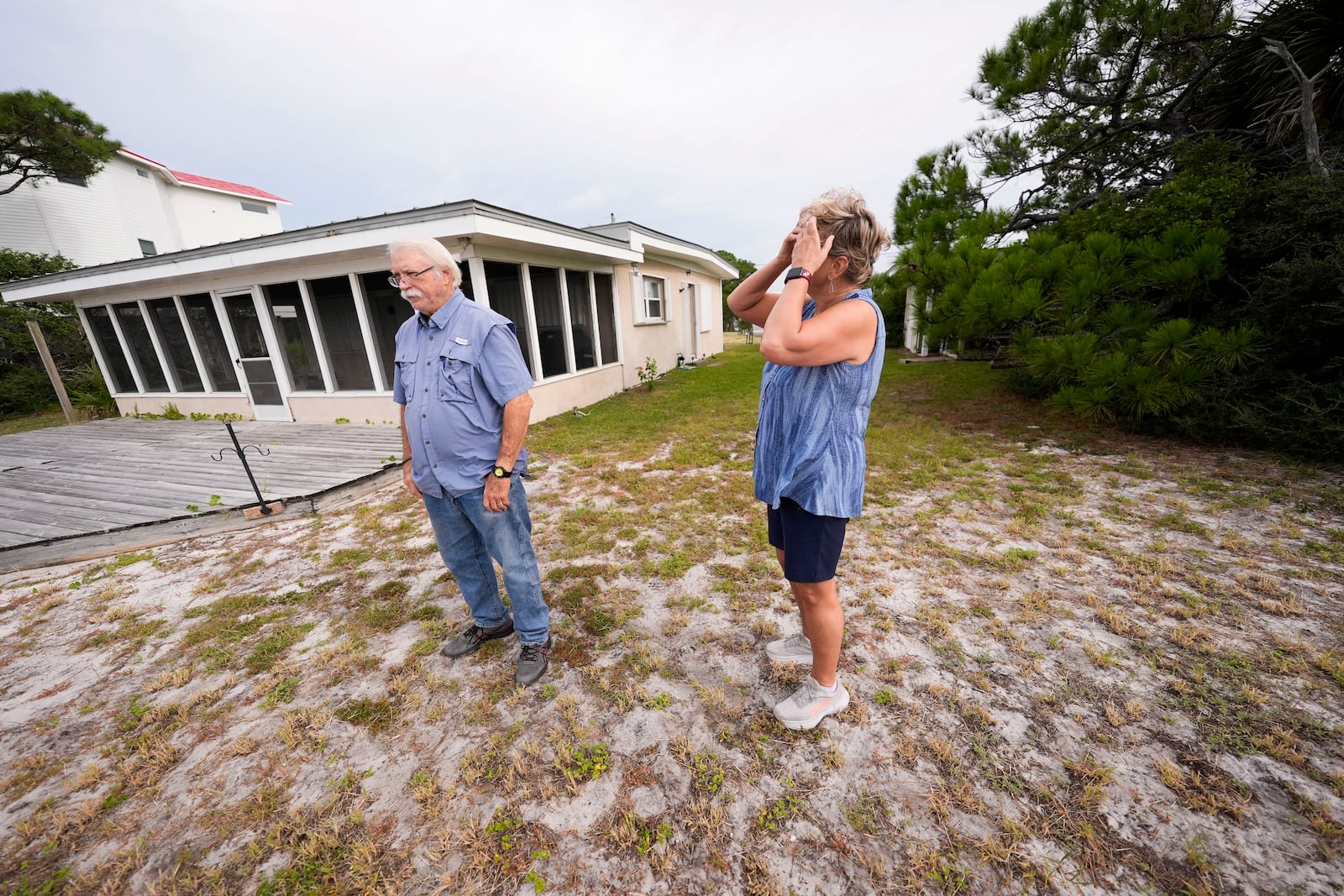 Paulette McLin takes in the scene outside their summer home ahead of Hurricane Helene, expected to make landfall Thursday evening, in Alligator Point, Fla., Wednesday, Sept. 25, 2024. (AP Photo/Gerald Herbert)