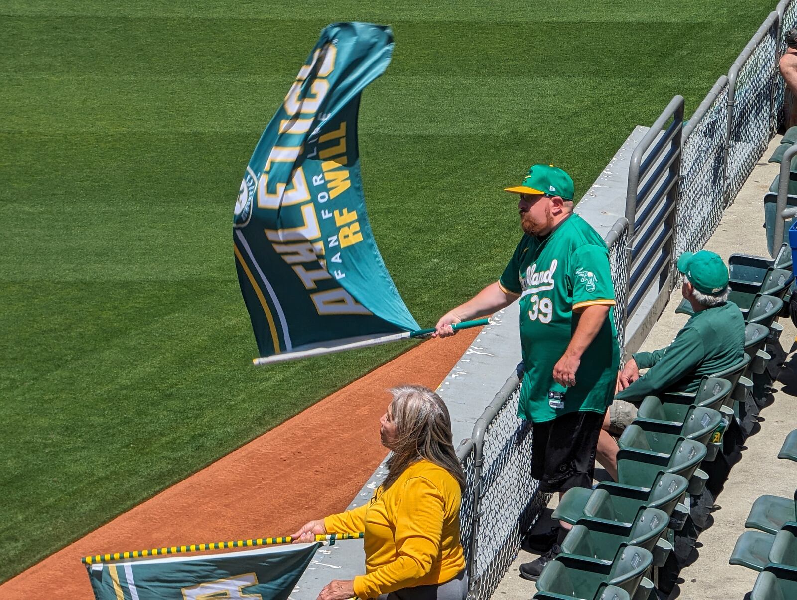 "Right-Field" Will MacNeil waves an A's flag as the home team prepares to take to the field during a game at the Oakland Coliseum on May 1, 2024, in Oakland, Calif.. (AP Photo/Michael Liedtke)