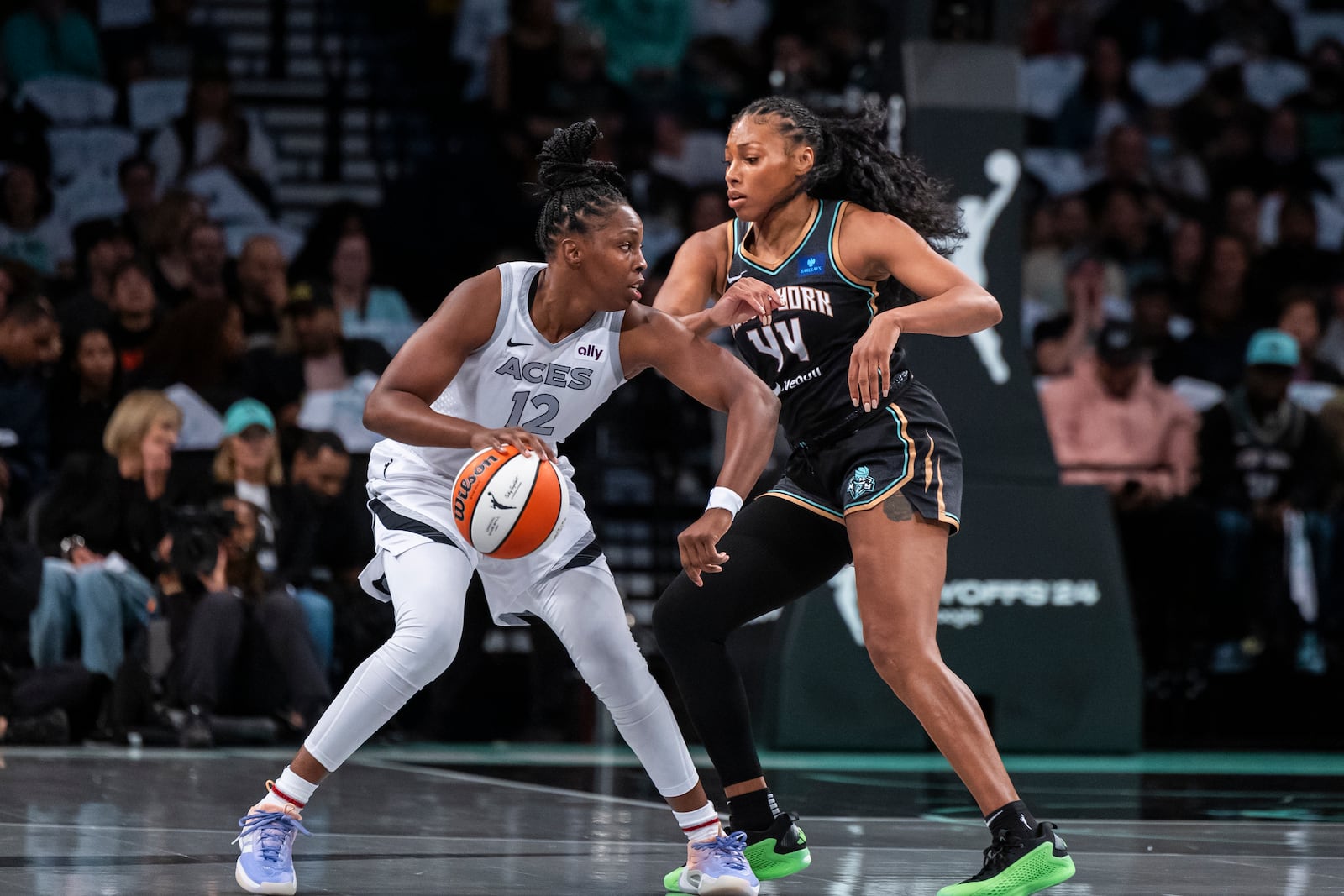 Las Vegas Aces guard Chelsea Gray (12) is defended by New York Liberty forward Betnijah Laney-Hamilton (44) during the first half of a WNBA basketball second-round playoff game, Sunday, Sept. 29, 2024, in New York. (AP Photo/Corey Sipkin)