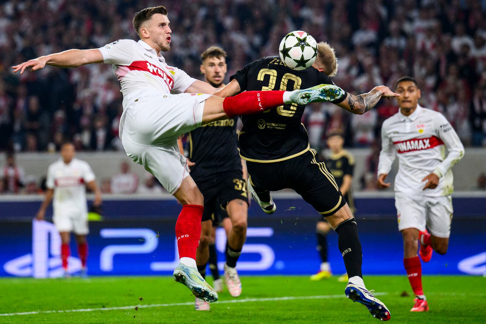 Stuttgart's Ermedin Demirovic, front left, and Prague's Jaroslav, front right, challenge for the ball during the Champions League opening phase soccer match between VfB Stuttgart and AC Sparta Praha in Stuttgart, Germany, Tuesday, Oct. 1, 2024. (Tom Weller/dpa via AP)