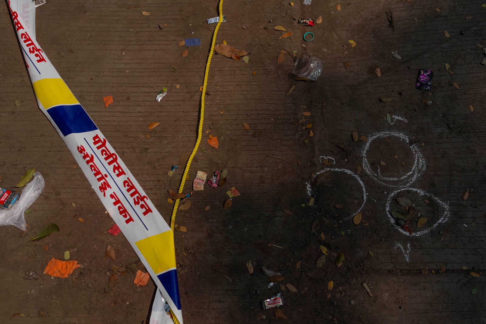 Marks made by a forensic team of the Mumbai police are visible on the spot where Baba Siddique, a senior politician, was shot at outside his son's office in Mumbai and later succumbed to his wounds in a hospital on Saturday night, in Mumbai, India, Sunday, Oct. 13, 2024. (AP Photo/Rafiq Maqbool)