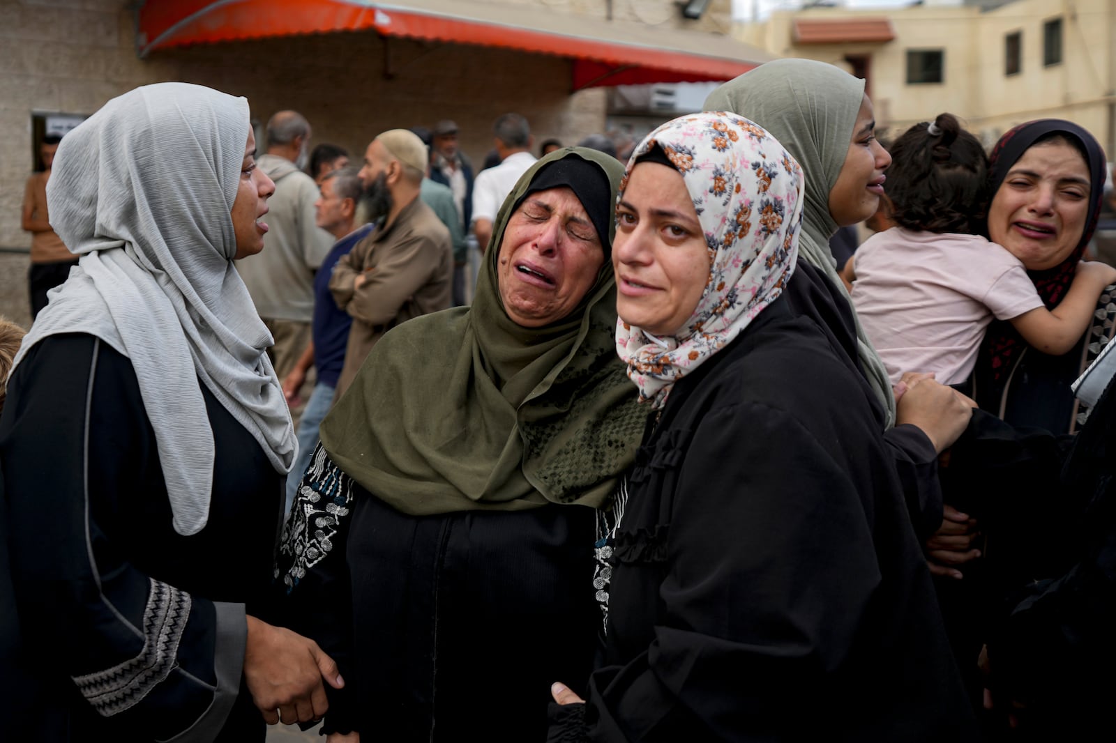 Palestinians mourn their relatives killed in the Israeli bombardment of the Gaza Strip at a hospital in Deir al-Balah, Tuesday, Oct. 8, 2024. (AP Photo/Abdel Kareem Hana)