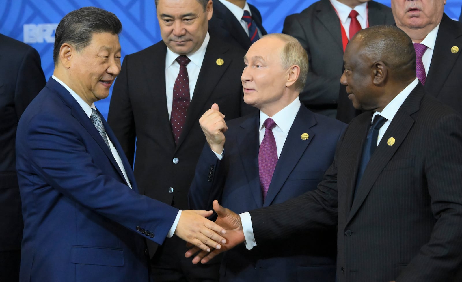 Russian President Vladimir Putin, center, gestures while Chinese President Xi Jinping, left, and South African President Cyril Ramaphosa shake hands during a family photo ceremony prior to Outreach/BRICS Plus format session on the sidelines of the the BRICS summit in Kazan, Russia, Thursday, Oct. 24, 2024. (Grigory Sysoyev/Photo host brics-russia2024.ru via AP)