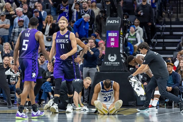 Minnesota Timberwolves center Rudy Gobert (27) sits on the floor after forward Jaden McDaniels fouls out of the game in the final minutes of overtime in an Emirates NBA Cup basketball game against the Sacramento Kings, Friday, Nov. 15, 2024, in Sacramento, Calif. (AP Photo/Sara Nevis)