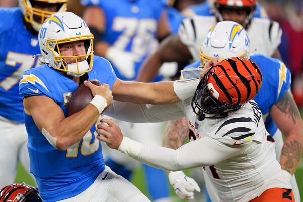 Los Angeles Chargers quarterback Justin Herbert (10) is pressured by Cincinnati Bengals defensive end Trey Hendrickson (91) during the first half of an NFL football game Sunday, Nov. 17, 2024, in Inglewood, Calif. (AP Photo/Gregory Bull)