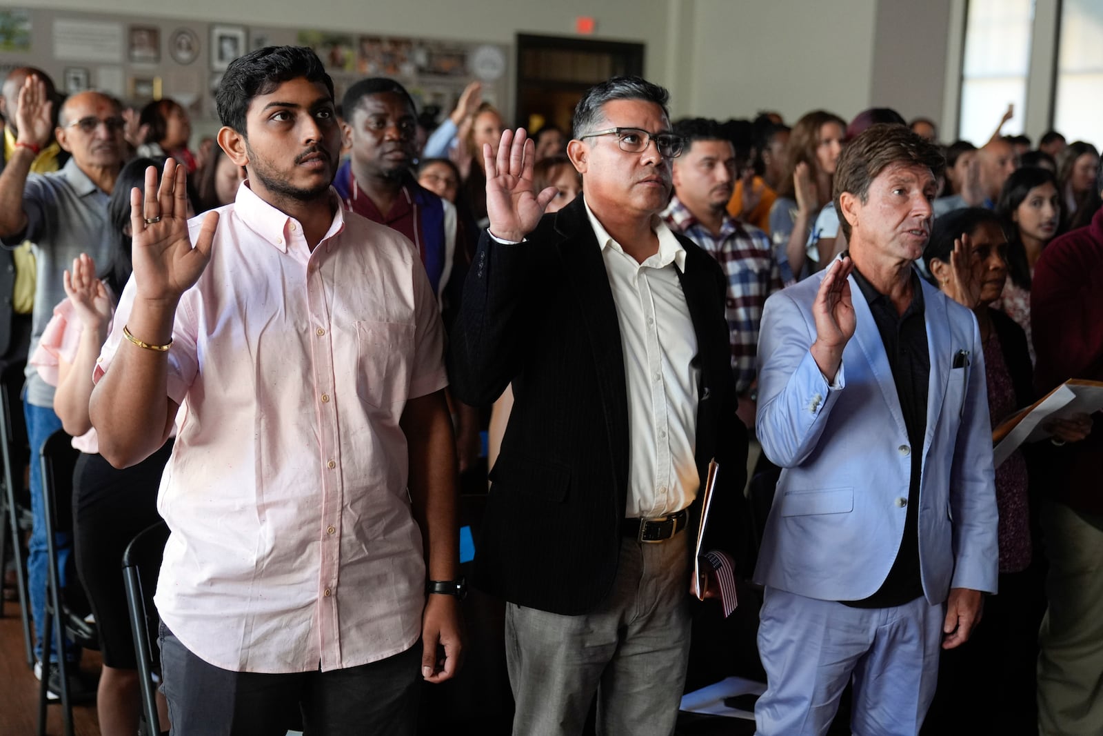 One hundred people take the oath to become American citizens during a naturalization ceremony at the high school attended by former President Jimmy Carter on Carter's 100th birthday Tuesday, Oct. 1, 2024, in Plains, Ga. (AP Photo/John Bazemore)