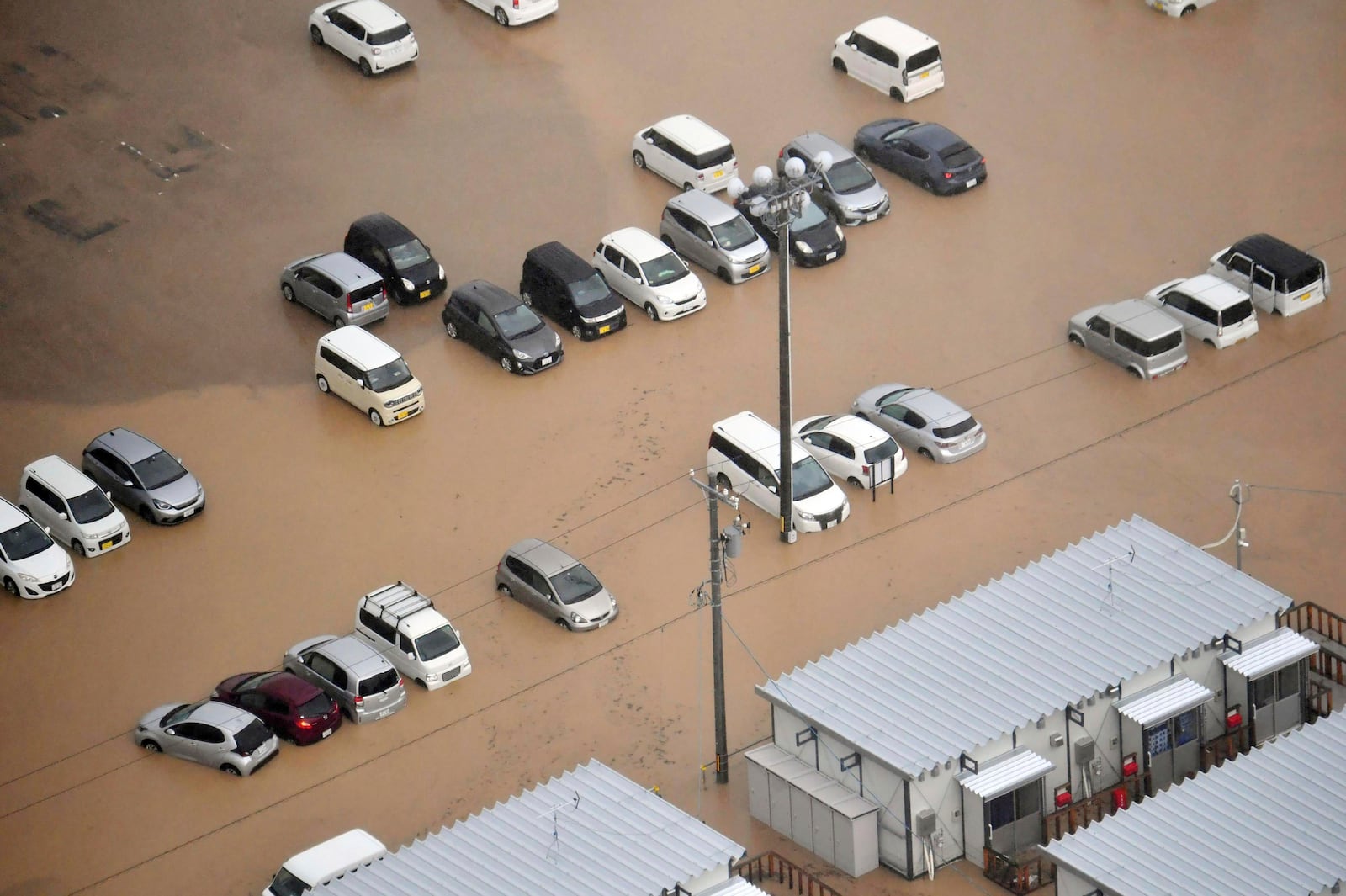 This aerial photo shows cars are submerged after heavy rain in Wajima, Ishikawa prefecture, Saturday, Sept. 21, 2024. (Kyodo News via AP)