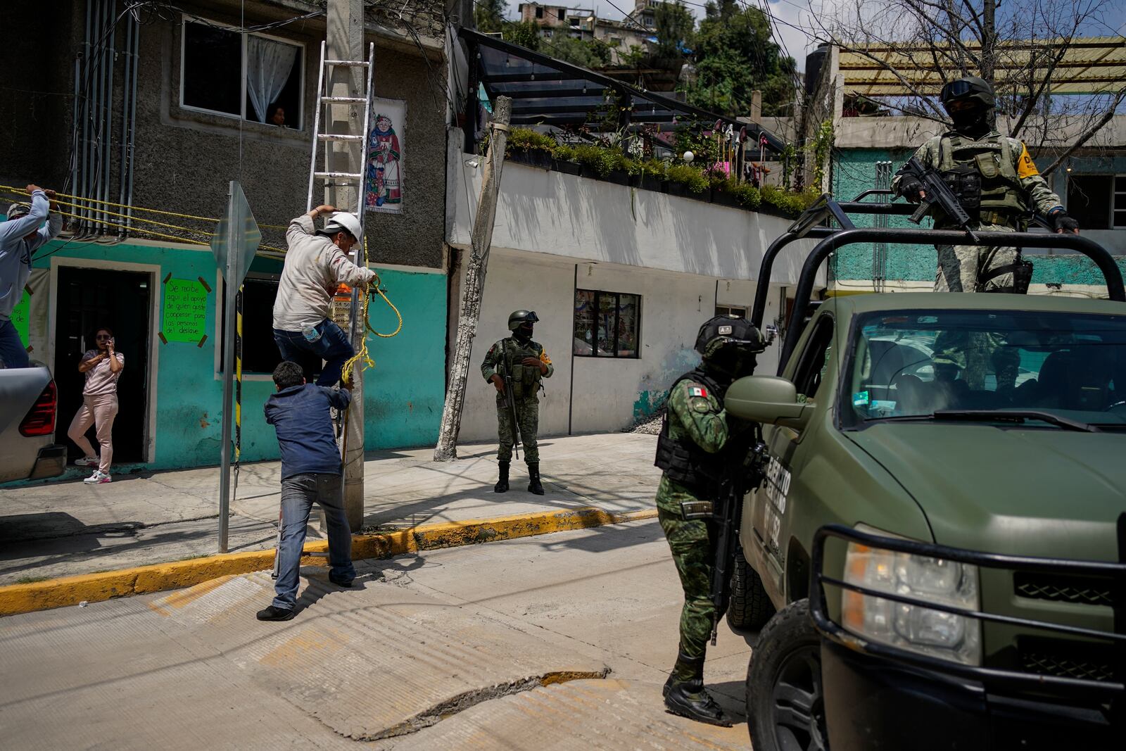 Soldiers guard the area where various people died after a rain-induced landslide, in Naucalpan, Mexico, Tuesday, Sept. 17, 2024. (AP Photo/Felix Marquez)