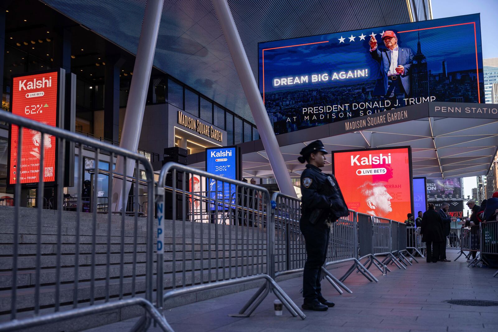 A police officer stands in front of the campaign video boards for Republican presidential nominee former President Donald Trump outside Madison Square Garden, Sunday, Oct. 27, 2024, in New York. (AP Photo/Yuki Iwamura)