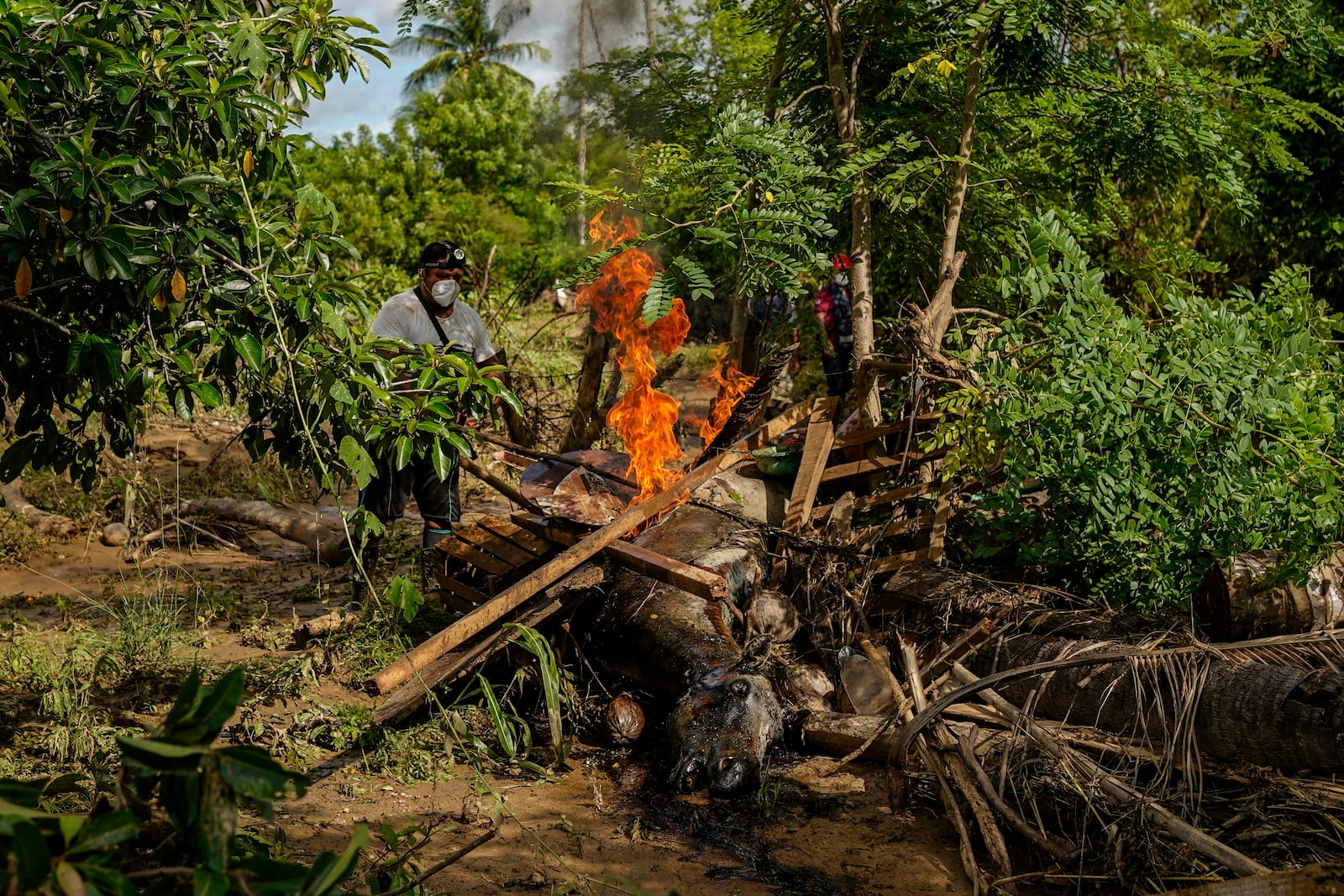 A man burns a dead horse after Hurricane John passed through Coyuca de Benitez, Guerrero state, Mexico, Monday, Sept. 30, 2024. (AP Photo/Felix Marquez)