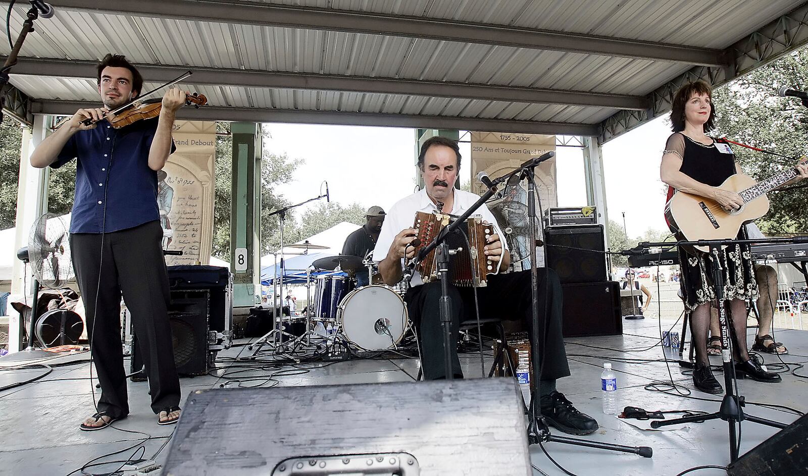 FILE - Savoy family members, Joel Savoy on fiddle, his father, Marc Savoy, on accordion and mother, Ann Savoy, play traditional Cajun music mixed with some contemporary tunes, Sept. 17, 2005, at the Festivals Acadiens in Lafayette, La. (AP Photo/Rogelio Solis, File)