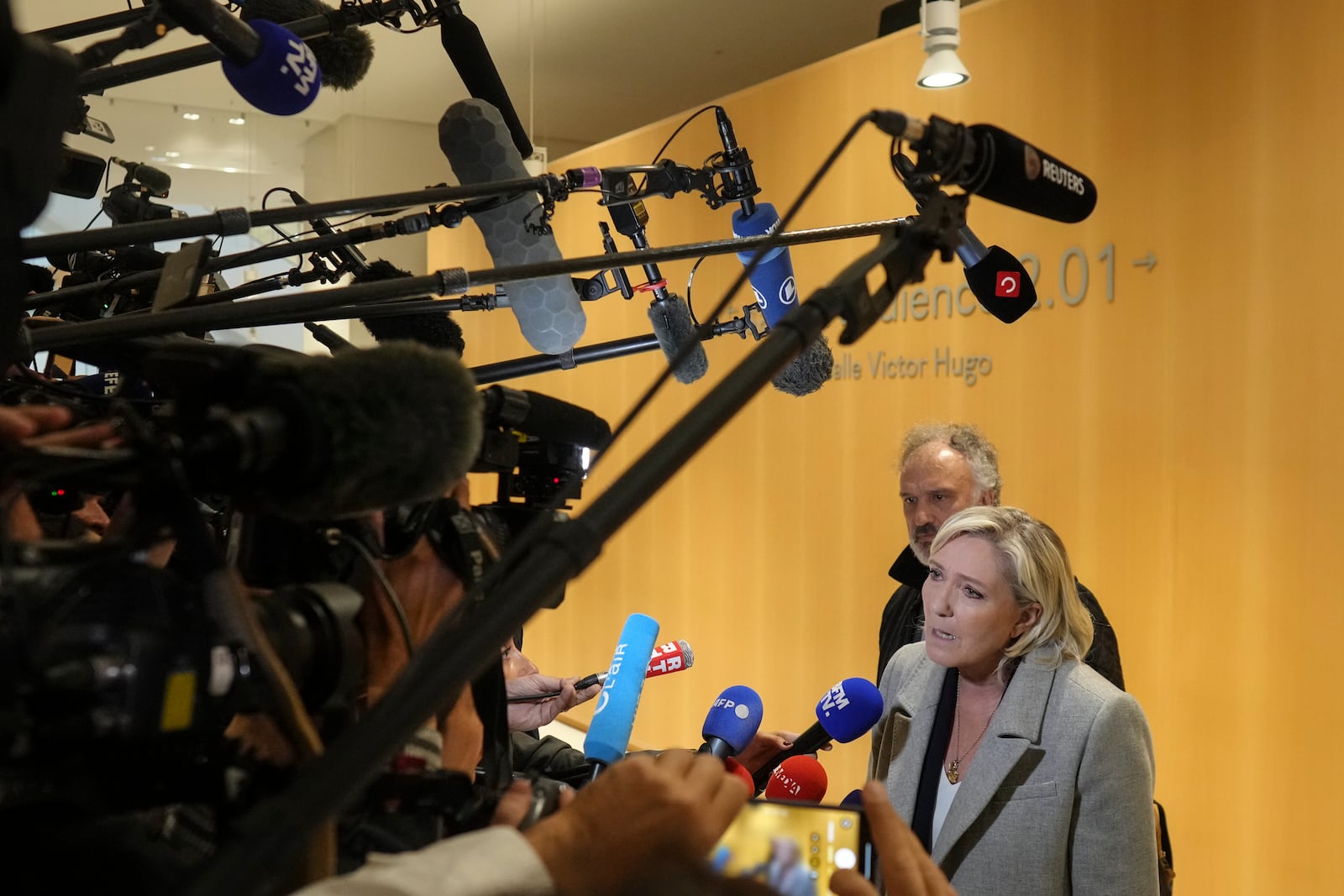 French far-right leader Marine Le Pen, front, speaks to the media as she arrives at the court house in Paris, Monday, Sept. 30, 2024. (AP Photo/Thibault Camus)