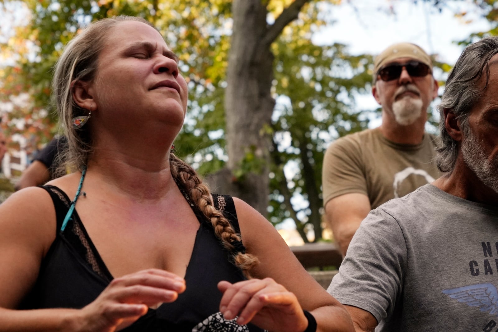 A woman plays music at a drum circle Friday, Oct. 4, 2024 in Asheville, N.C., a week after Hurricane Helene upended lives across the Southeast. (AP Photo/Brittany Peterson)