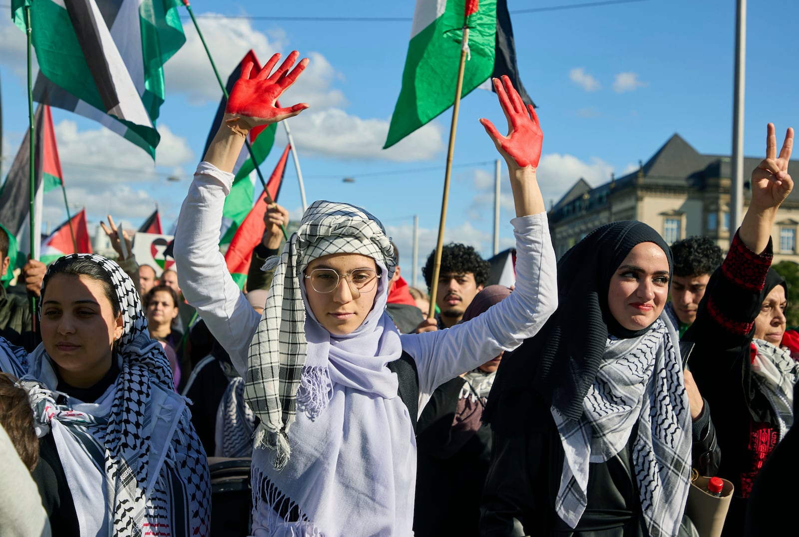 A participant in a pro-Palestinian rally holds up her red-painted hands on the Steintordamm, in Hamburg, Germany, Saturday, Oct. 5, 2024. (Georg Wendt/dpa via AP)