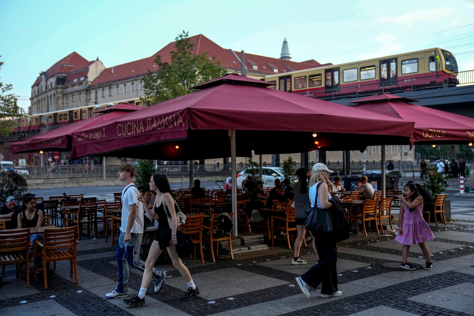 People eat doner in the outdoor area of a doner kebab restaurant in Berlin, Germany, Wednesday, Sept. 18, 2024. (AP Photo/Ebrahim Noroozi)