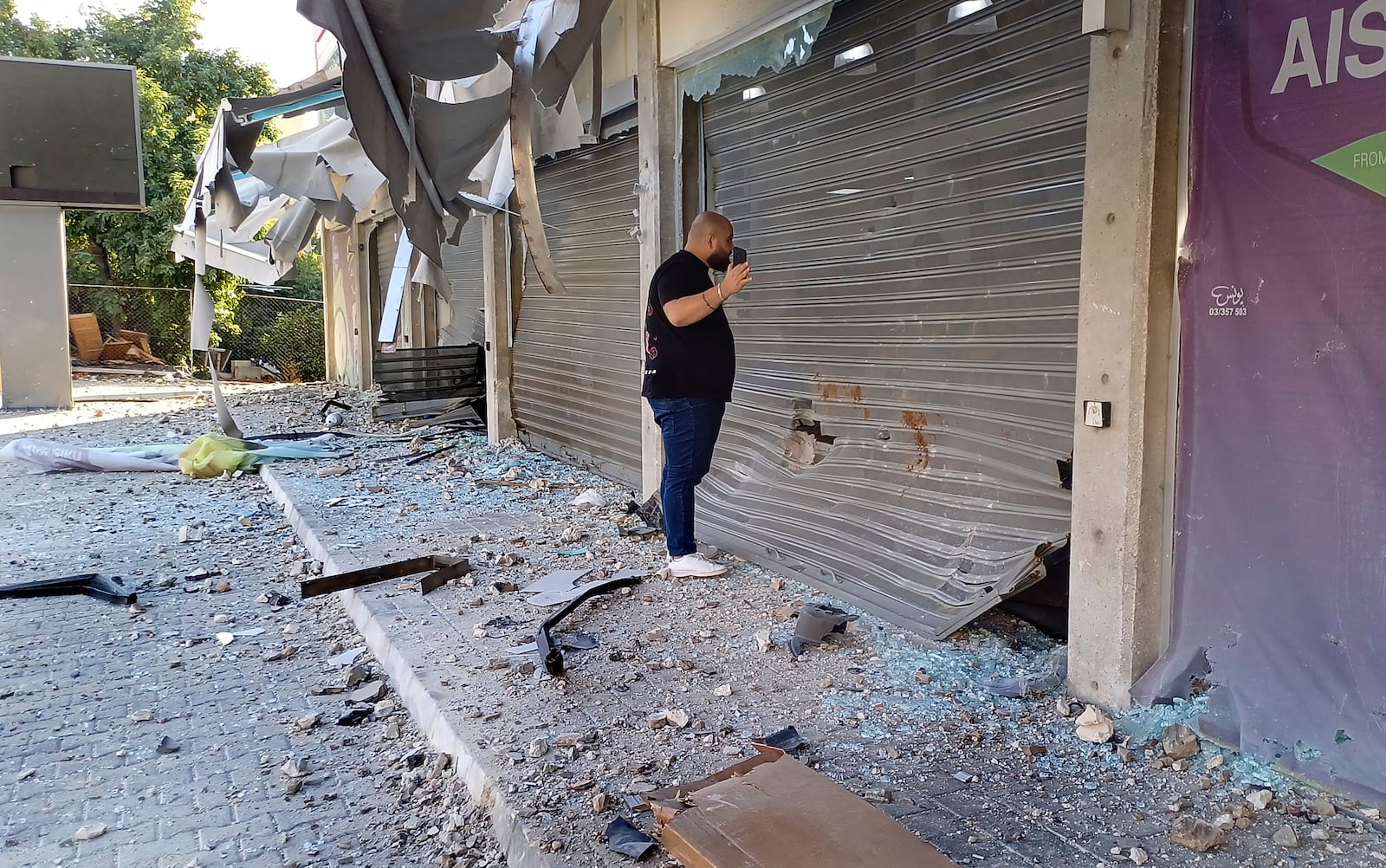 A man checks damaged shops at the site of an Israeli airstrike that hit a building, in the southern port city of Sidon, Lebanon, Sunday, Oct. 27, 2024. (AP Photo/Mohammed Zaatari)