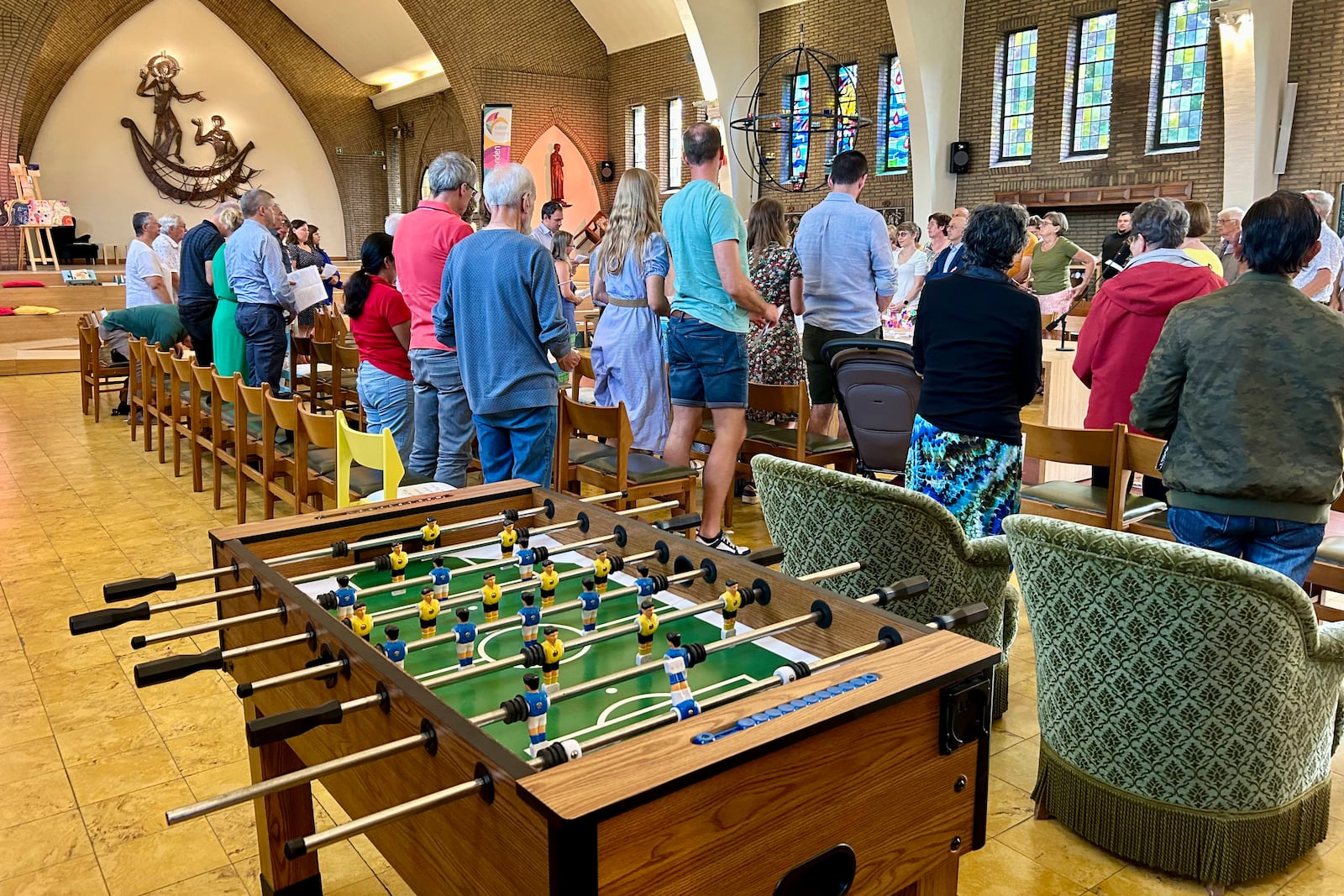 Parishioners stand together during a service at the Don Bosco Church in Buizingen, Belgium, Sunday, Sept. 1, 2024. (AP Photo/Raf Casert)