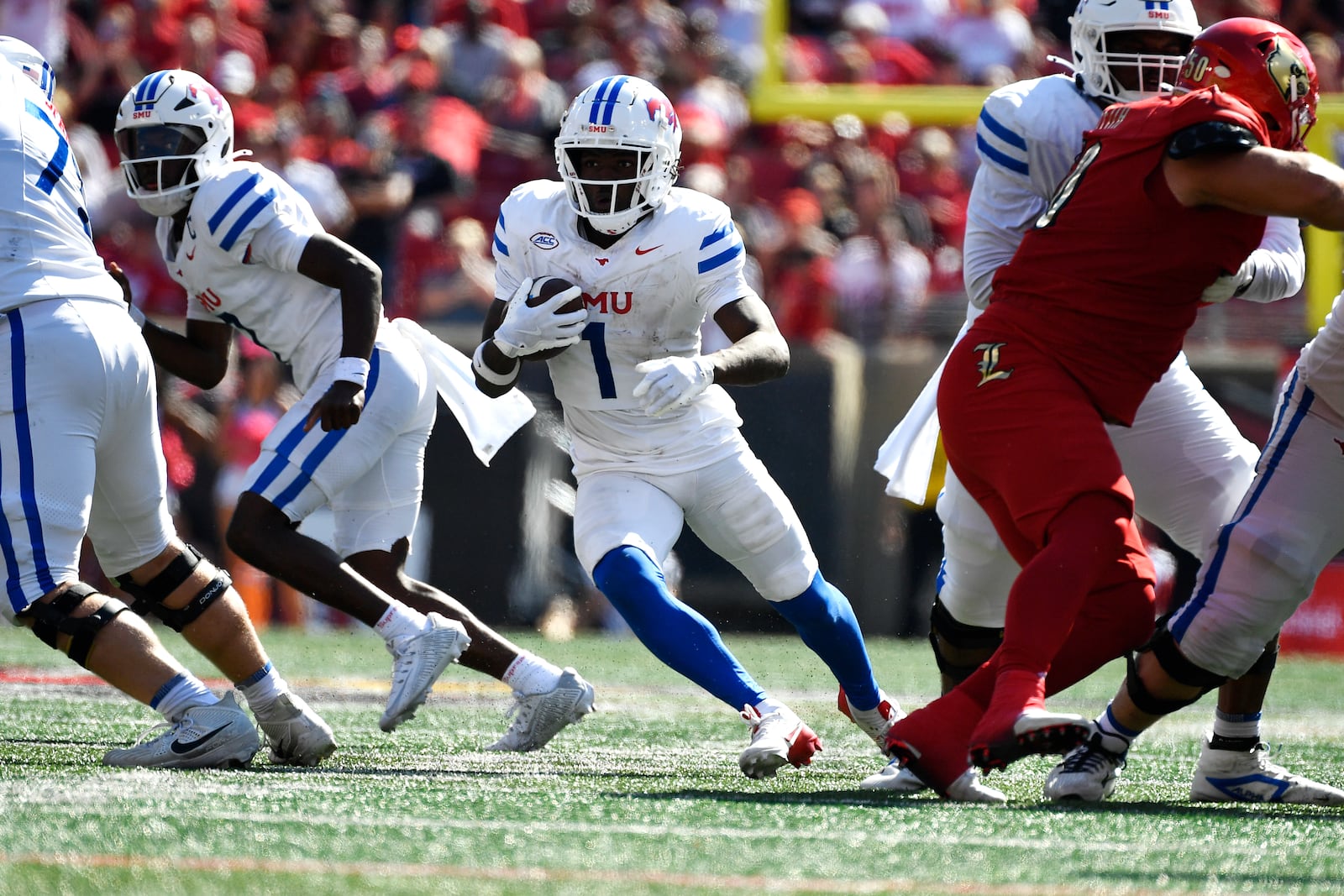 SMU running back Brashard Smith (1) runs through an opening in the Louisville line during the second half of an NCAA college football game in Louisville, Ky., Saturday, Oct. 5, 2024. (AP Photo/Timothy D. Easley)