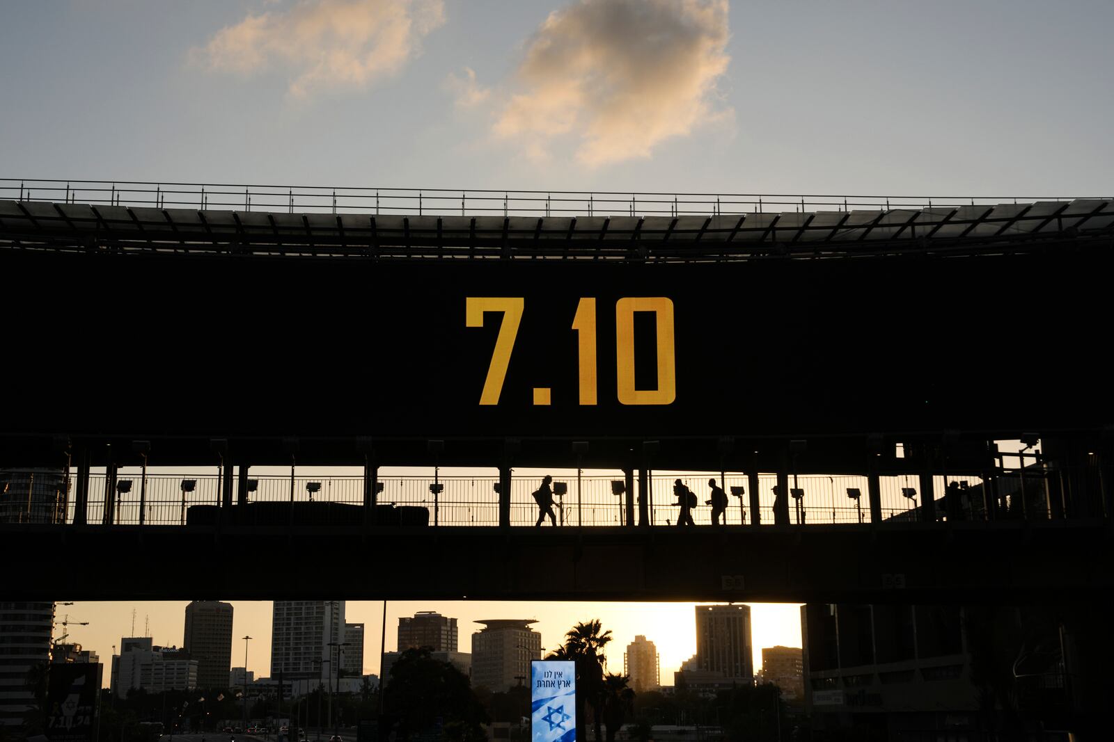 People cross a bridge with the date 7.10, marking the one-year anniversary of the Hamas attack on Israel, in Ramat Gan, Israel, Monday, Oct. 7, 2024. (AP Photo/Oded Balilty)