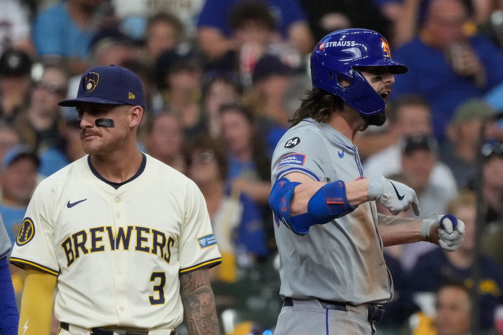 New York Mets' Jesse Winker reacts in front of Milwaukee Brewers third base Joey Ortiz after hitting a two-run scoring triple during the second inning of Game 2 of a National League wild card baseball game Tuesday, Oct. 1, 2024, in Milwaukee. (AP Photo/Morry Gash)