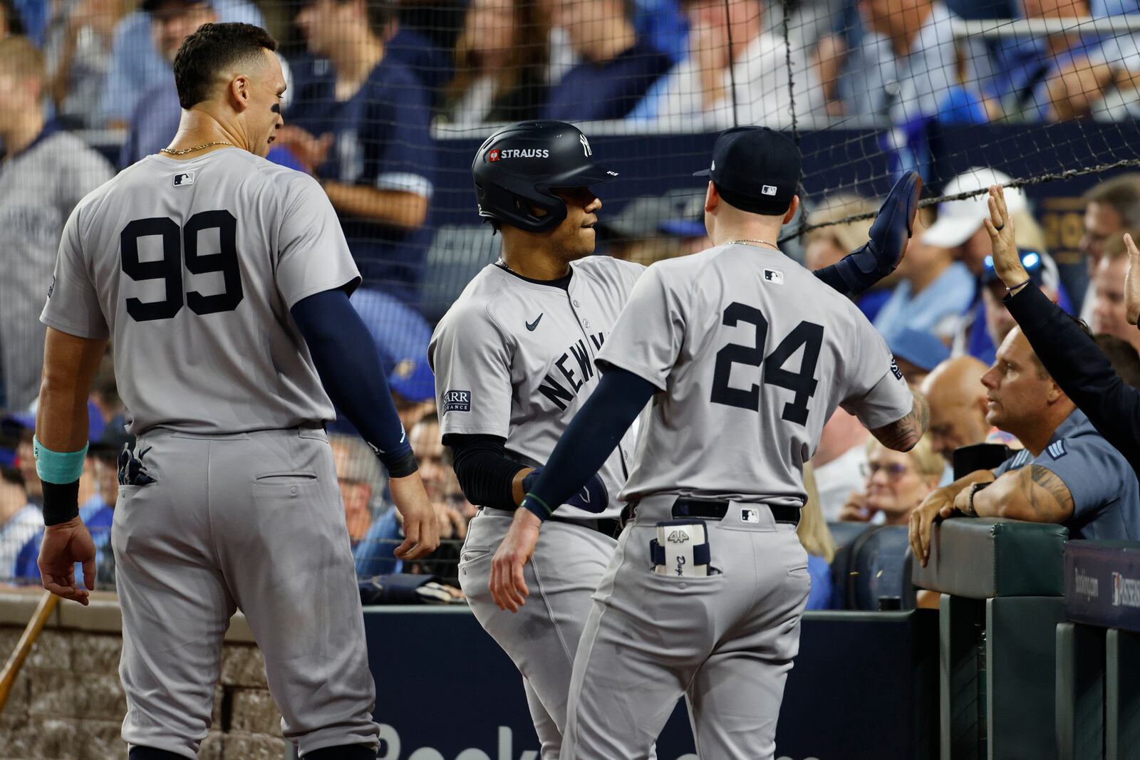 New York Yankees' Juan Soto, center, is congratulated by teammates Aaron Judge (99) and Alex Verdugo (24) after scoring during the fourth inning in Game 3 of an American League Division baseball playoff series against the Kansas City Royals Wednesday, Oct. 9, 2024, in Kansas City, Mo. (AP Photo/Colin Braley)