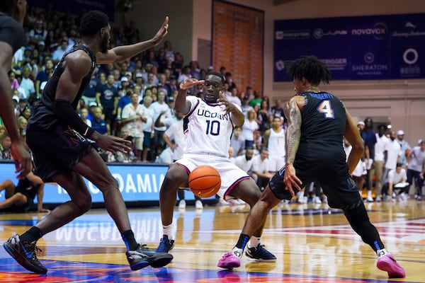 UConn guard Hassan Diarra (10) loses the ball against Memphis center Moussa Cisse, left, and guard PJ Haggerty (4) during the first half of an NCAA college basketball game at the Maui Invitational Monday, Nov. 25, 2024, in Lahaina, Hawaii. (AP Photo/Lindsey Wasson)