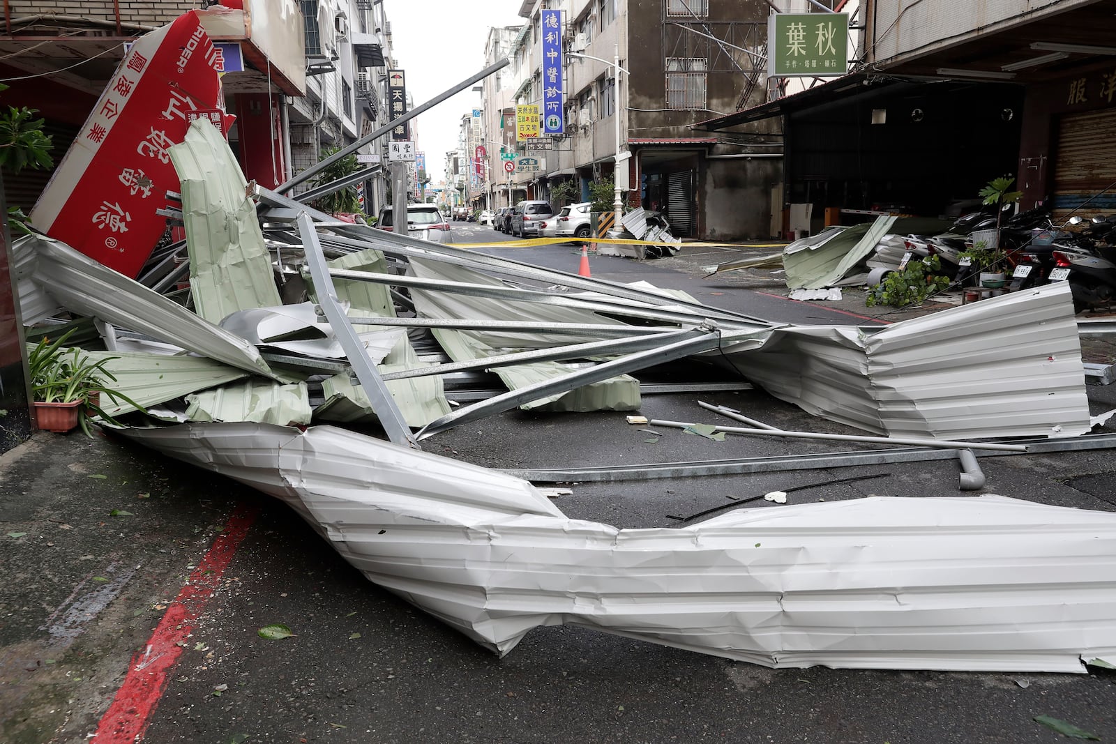 A blown roof destroyed by the wind of Typhoon Krathon, lay across a road in Kaohsiung, southern Taiwan, Friday, Oct. 4, 2024. (AP Photo/Chiang Ying-ying)