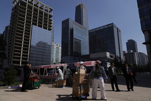 Vendors pull their goods as they closed their stores after a lunch break at the Central Business District, in Beijing, Monday, April 28, 2025. (AP Photo/Andy Wong)