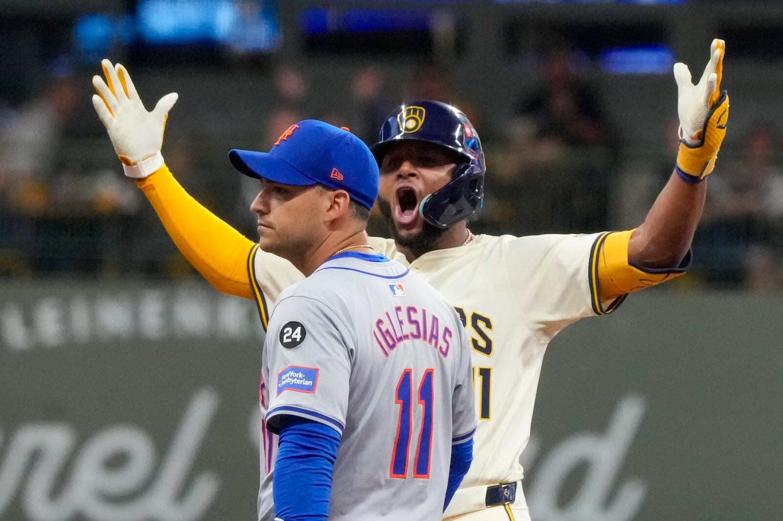 Milwaukee Brewers' Jackson Chourio reacts in front of New York Mets' Jose Iglesias after hitting an RBI double during the fourth inning of Game 2 of a National League wild card baseball game Tuesday, Oct. 1, 2024, in Milwaukee. (AP Photo/Morry Gash)