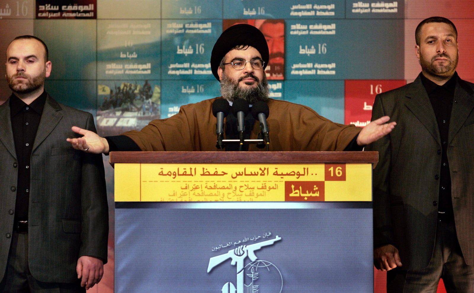 FILE - Hezbollah leader Hassan Nasrallah, flanked by two bodyguards, speaks to thousands of supporters in Beirut's southern suburbs, Friday, Feb. 16, 2007. (AP Photo/Ben Curtis, File)