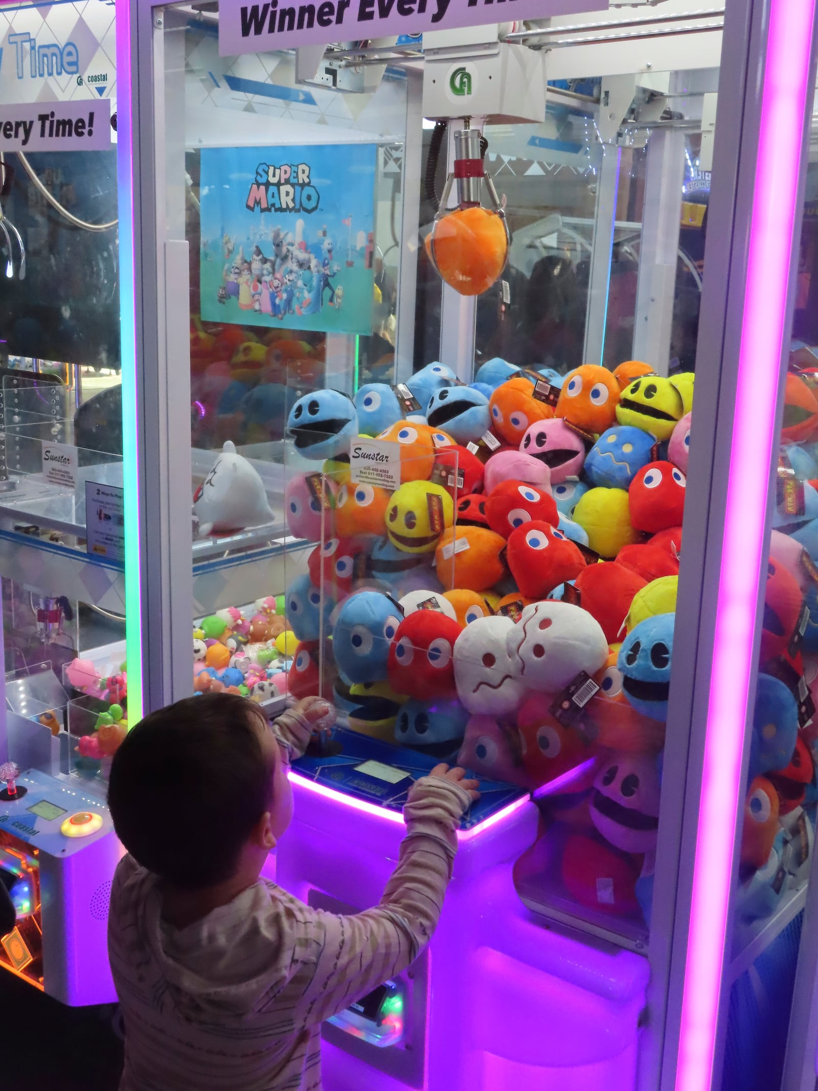 A child wins a prize in an arcade game at Gillian's Wonderland on the Ocean City N.J. boardwalk on Sunday, Oct. 13, 2024, the popular amusement park's final day of operation before shutting down for good. (AP Photo/Wayne Parry)