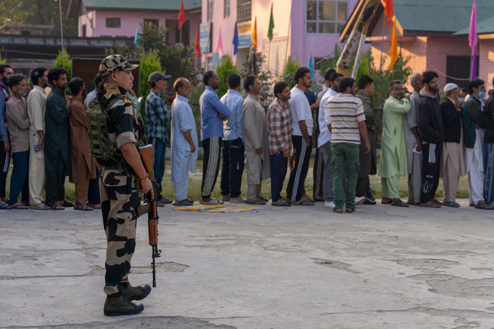 An Indian paramilitary soldier stands guard as Kashmiri's queue up at a polling booth to cast their vote during the second phase of the assembly election in the outskirts of Srinagar, Indian controlled Kashmir, Wednesday, Sept. 25, 2024. (AP Photo/Dar Yasin)