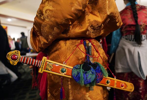 Elders dress in traditional clothing to perform a ceremonial Tibetan dance to welcome U.S.-born Buddhist lama, Jalue Dorje, to his 18th birthday and enthronement ceremony in Isanti, Minn., on Saturday, Nov. 9, 2024. (AP Photo/Jessie Wardarski)