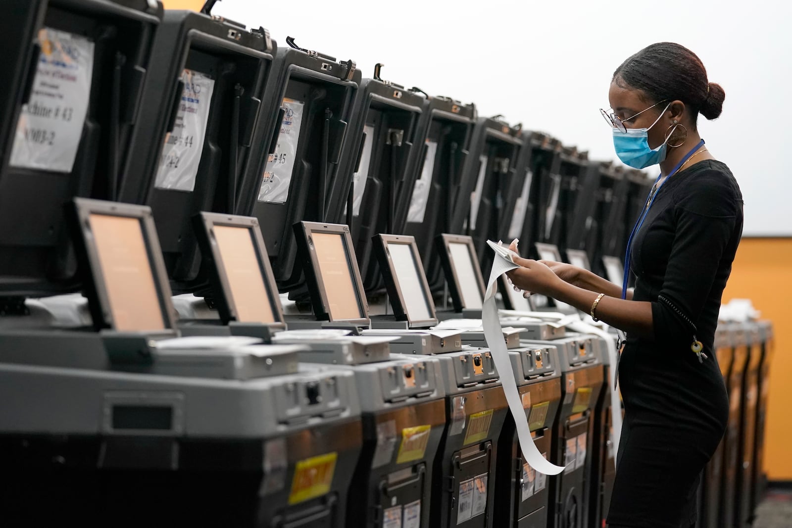 FILE - An employee at the Broward Supervisor of Elections Office conducts logic and accuracy testing of equipment used for counting ballots, Thursday, Sept. 24, 2020, in Lauderhill, Fla. (AP Photo/Lynne Sladky, File)