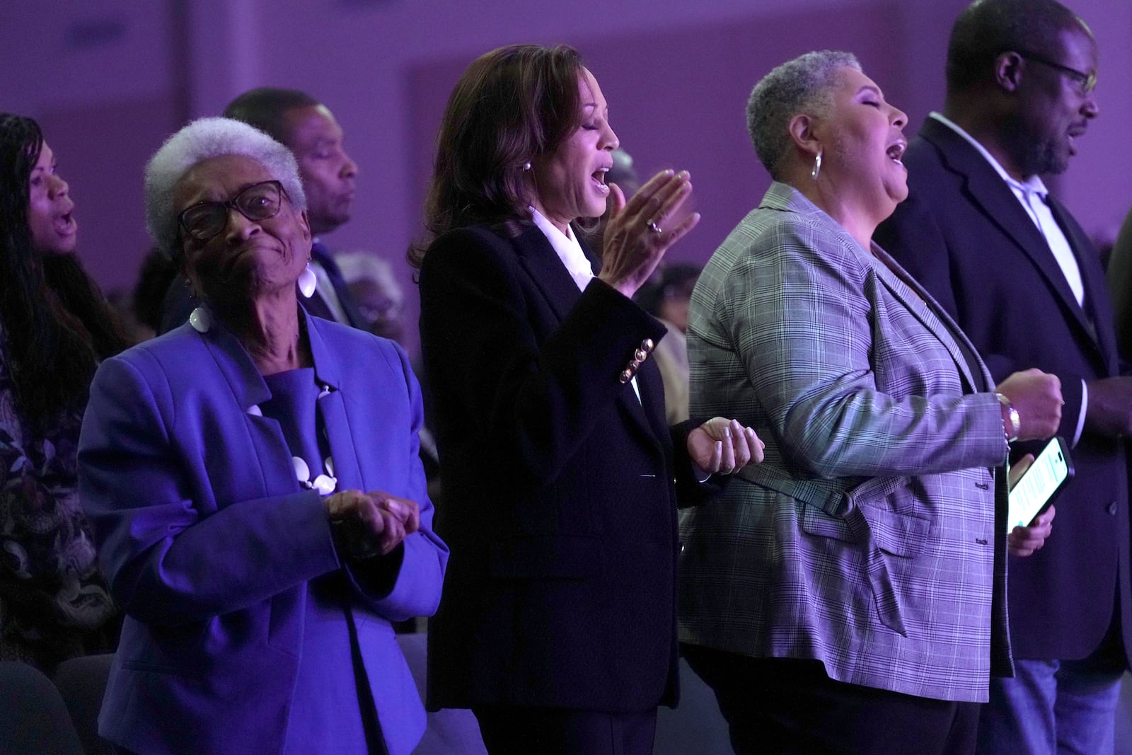 Democratic presidential nominee Vice President Kamala Harris, center, sings alongside former Rep. Eva Clayton, of North Carolina, left, and bishop Rosie O'neal, during a church service at Koinonia Christian Center in Greenville, N.C., Sunday, Oct. 13, 2024. (AP Photo/Susan Walsh)