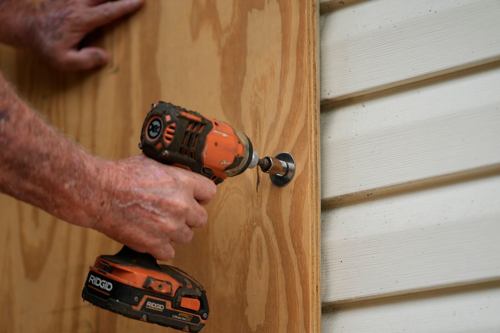 Dave McCurley boards up the windows to his home in advance of Tropical Storm Helene, expected to make landfall as a hurricane, in Ochlockonee Bay, Fla., Wednesday, Sept. 25, 2024. (AP Photo/Gerald Herbert)