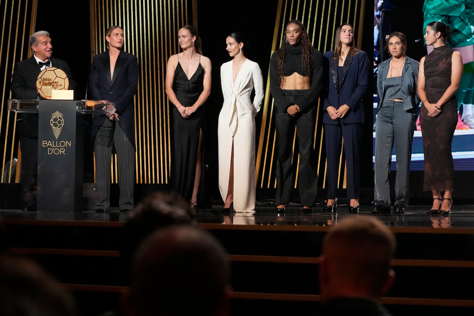 Barcelona's President Joan Laporta, left, and Spanish players from left, Alexia Putellas, Caroline Graham Hansen, Aitana Bonmati, Salma Paralluelo, Patri Guijarro, Mariona Caldentey, Marta Torrejon as they receive the Best Women's Club of the Year trophy during the 68th Ballon d'Or (Golden Ball) award ceremony at Theatre du Chatelet in Paris, Monday, Oct. 28, 2024. (AP Photo/Michel Euler)