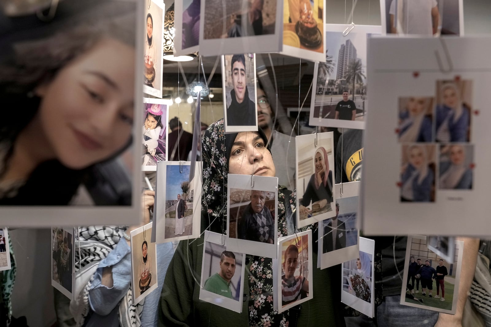 A woman views photos of Palestinian victims who were killed during the Israel war against Hamas, at a photo exhibition, (Gaza Habibti), Gaza my love, to commemorate the one-year anniversary of the war in the Gaza Strip, in Cairo, Egypt, Monday, Oct. 7, 2024. (AP Photo/Amr Nabil)