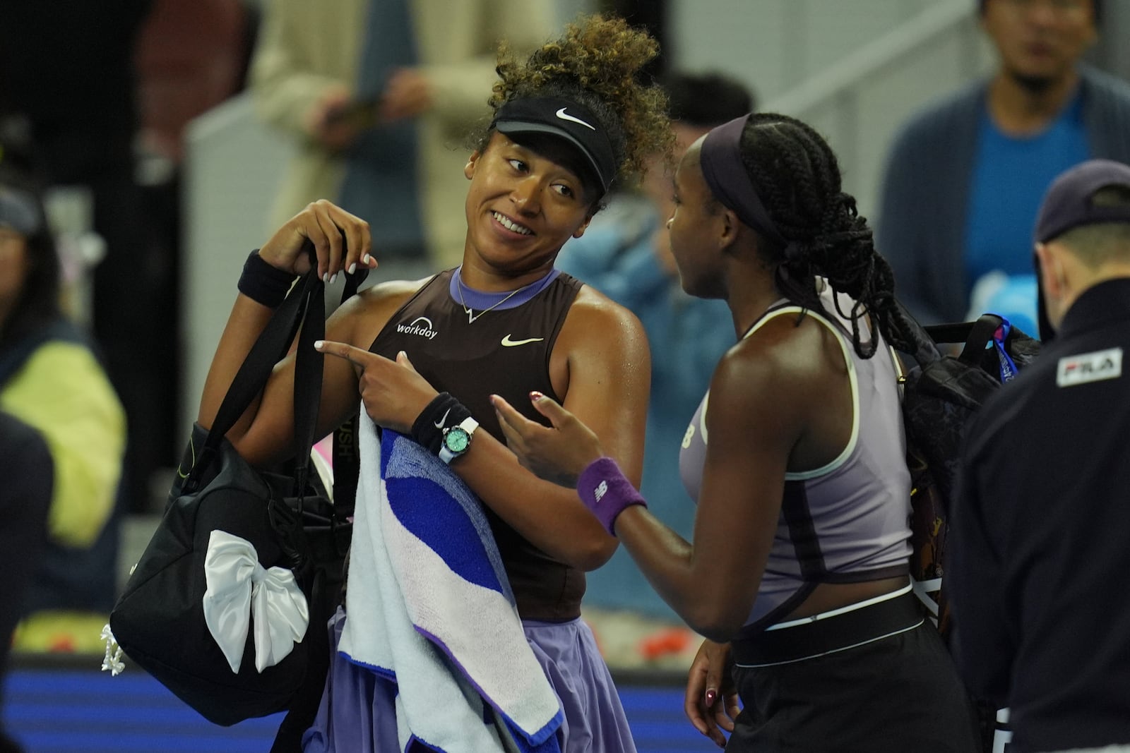 Coco Gauff of the United States speaks to Naomi Osaka of Japan after Osaka retired due to a injury in a women's singles match for the China Open tennis tournament held at the National Tennis Center in Beijing, Tuesday, Oct. 1, 2024. (AP Photo/Ng Han Guan)