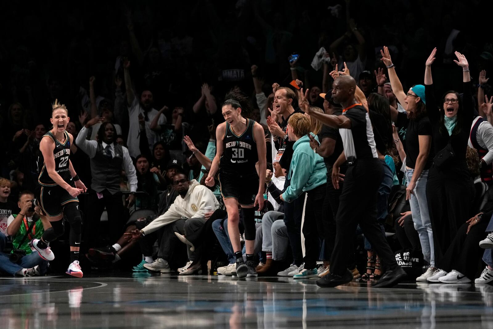 New York Liberty's Courtney Vandersloot (22) and Breanna Stewart (30) react after Steward scored a 3-point basket during the second half in Game 2 of a WNBA basketball final playoff series against the Minnesota Lynx, Sunday, Oct. 13, 2024, in New York. (AP Photo/Pamela Smith)